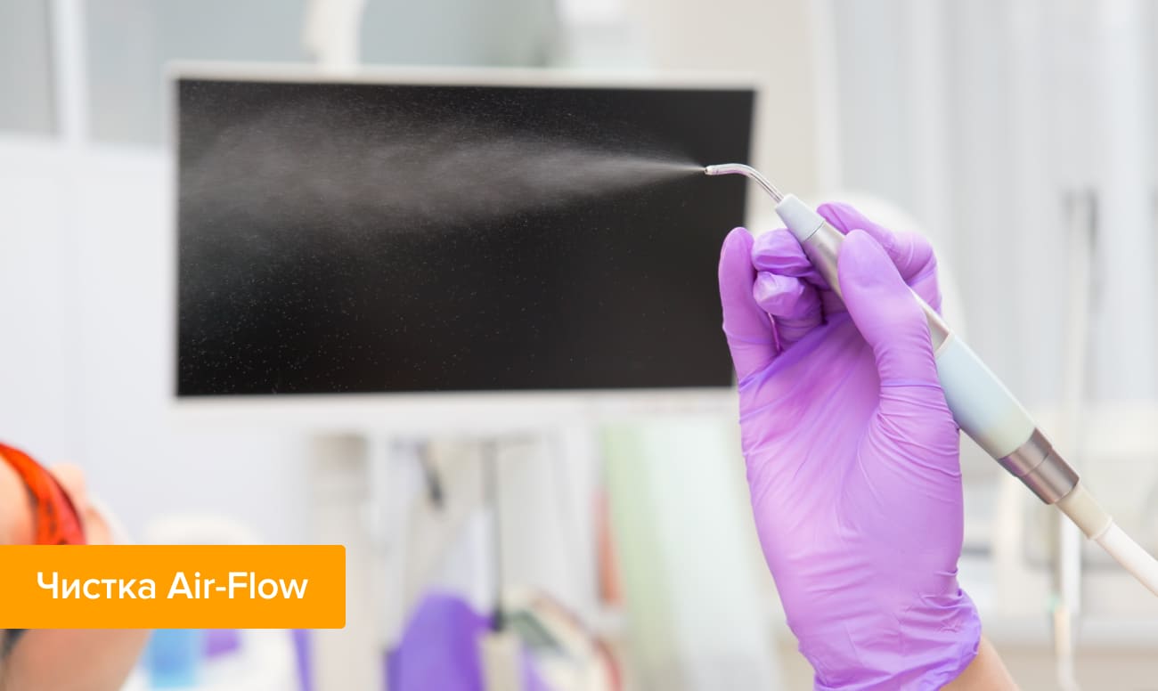Фото аппарата Air-Flow для чистки зубов, в руках стоматолога