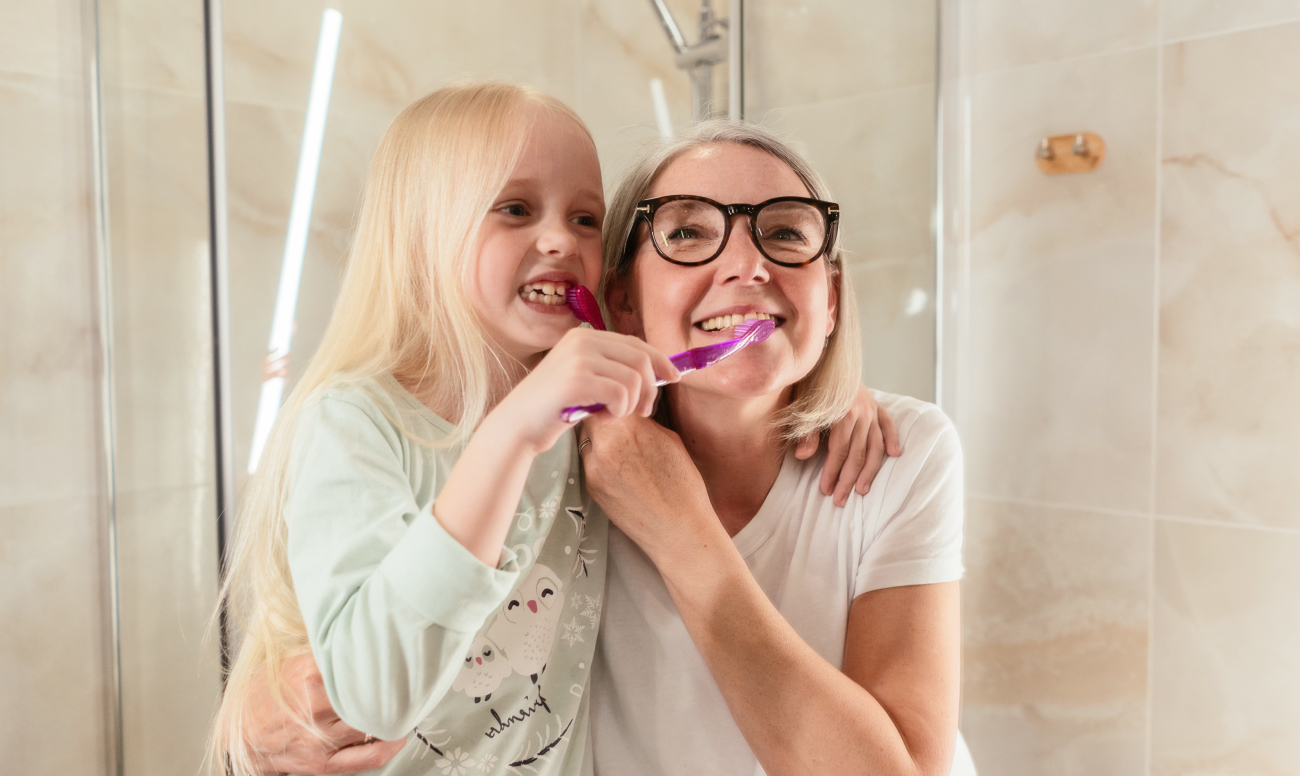 Фото мамы и ребенка во время совместной чистки зубов.