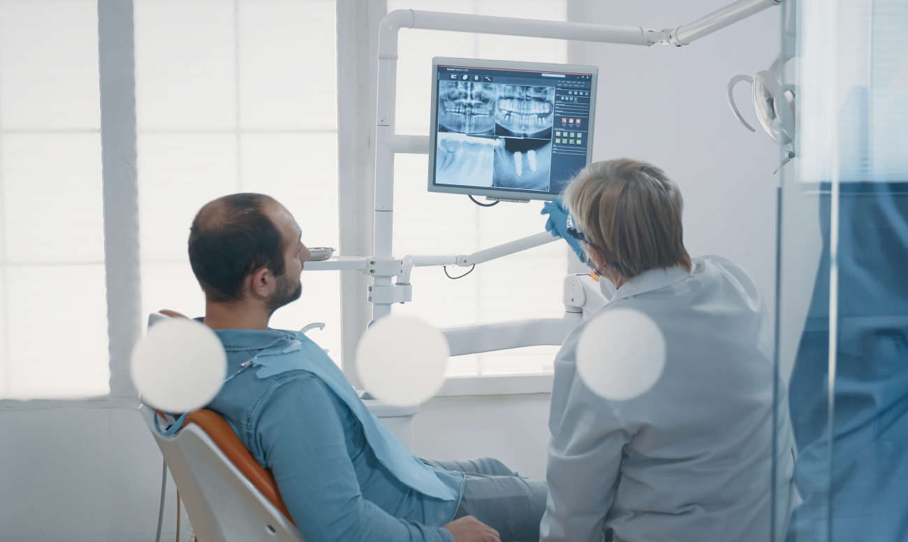Фото пациента в кресле стоматолога во время диагностики перед имплантацией.
