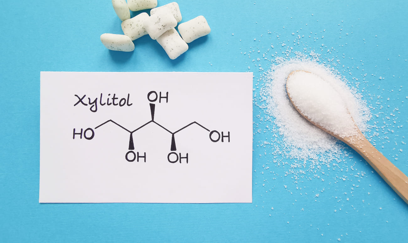 Фото химической формулы ксилита и жевательной резинки с ксилитом