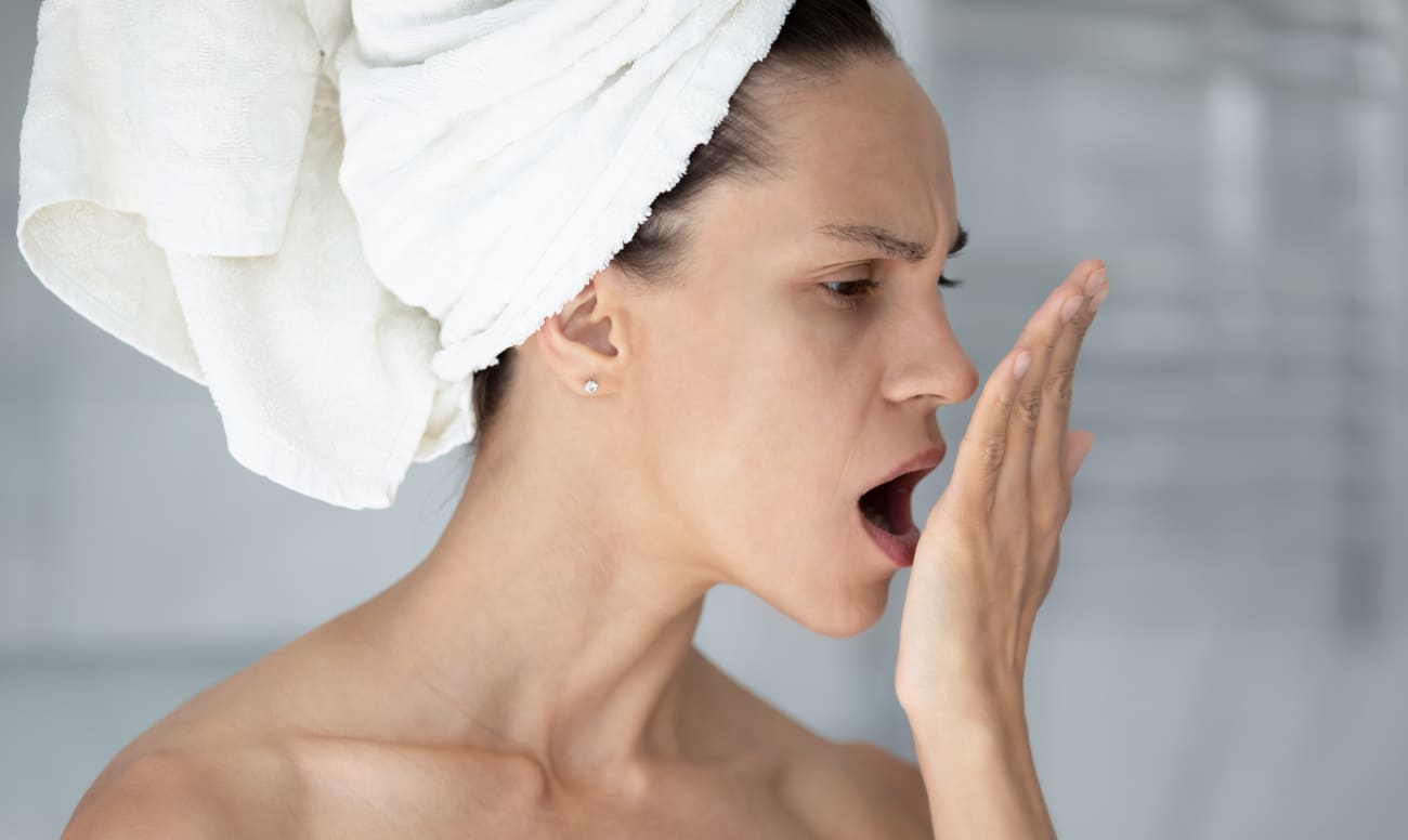 Фото девушки с помощью ладони проверяющей наличие запаха изо рта